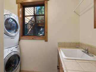 This laundry room features a stacked washer and dryer for space efficiency.