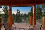 Enjoy breathtaking mountain views from this stunning log cabin deck, complete with comfortable seating and a glass railing for unobstructed scenery.