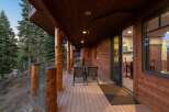 Experience the perfect blend of rustic charm and modern comfort on this expansive wooden deck, nestled amongst towering pine trees.