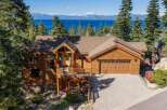Experience breathtaking lake and mountain views from this stunning wooden home, nestled amidst tall pine trees.