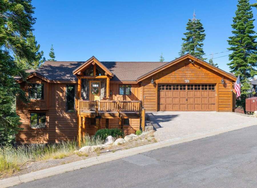 Experience rustic charm in this beautiful wooden home, featuring a spacious deck perfect for enjoying the surrounding nature.