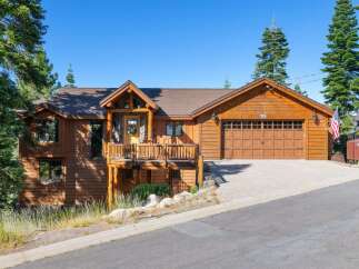 Experience rustic charm in this beautiful wooden home, featuring a spacious deck perfect for enjoying the surrounding nature.