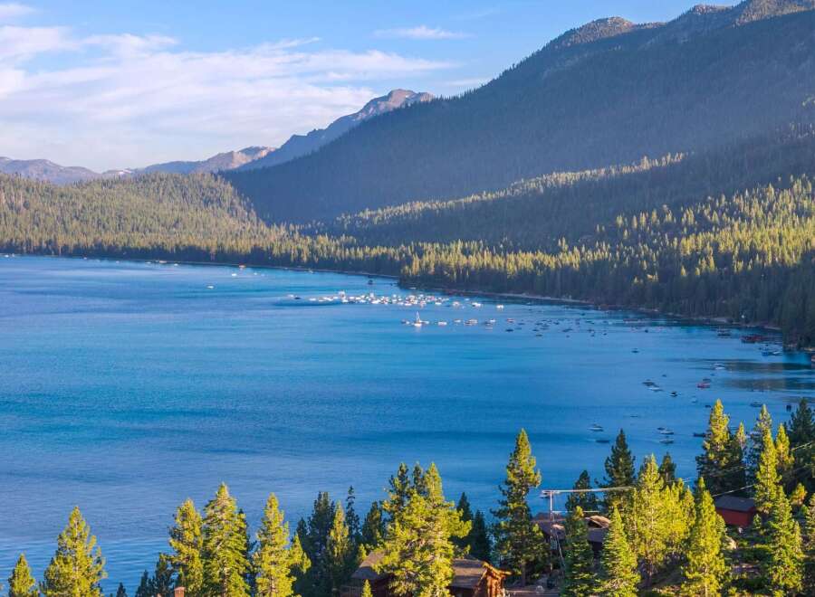 Experience the ultimate lakeside living with this stunning property offering breathtaking views of a serene blue lake and majestic mountains.