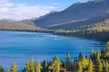 Experience the ultimate lakeside living with this stunning property offering breathtaking views of a serene blue lake and majestic mountains.