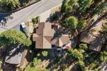 Discover this stunning aerial view of a multi-level home nestled amidst lush trees and natural rock formations.