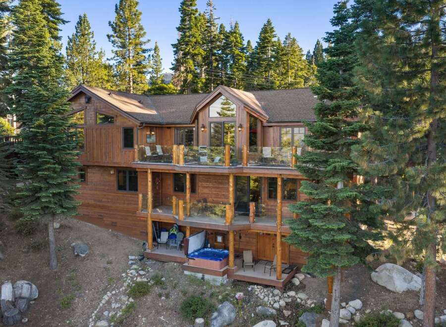 Experience luxury mountain living in this stunning wooden home nestled among tall pine trees.
