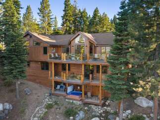 Experience luxury mountain living in this stunning wooden home nestled among tall pine trees.