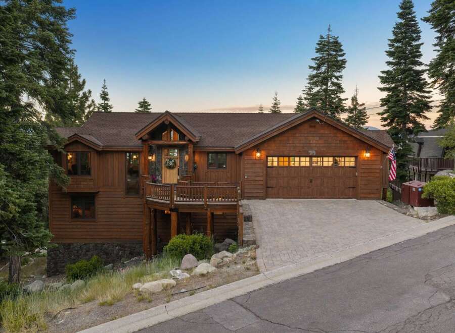 Experience rustic charm in this stunning mountain home, featuring rich wood siding and a welcoming covered porch.