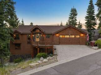 Experience rustic charm in this stunning mountain home, featuring rich wood siding and a welcoming covered porch.