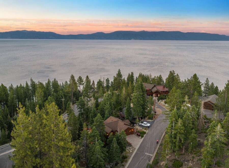 Experience breathtaking lake views from this stunning property nestled among tall pine trees.