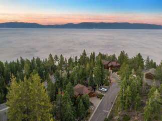 Experience breathtaking lake views from this stunning property nestled among tall pine trees.