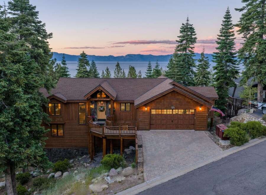 Experience breathtaking lake and mountain views from this stunning custom-built home nestled among tall pine trees.