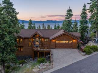 Experience breathtaking lake and mountain views from this stunning custom-built home nestled among tall pine trees.