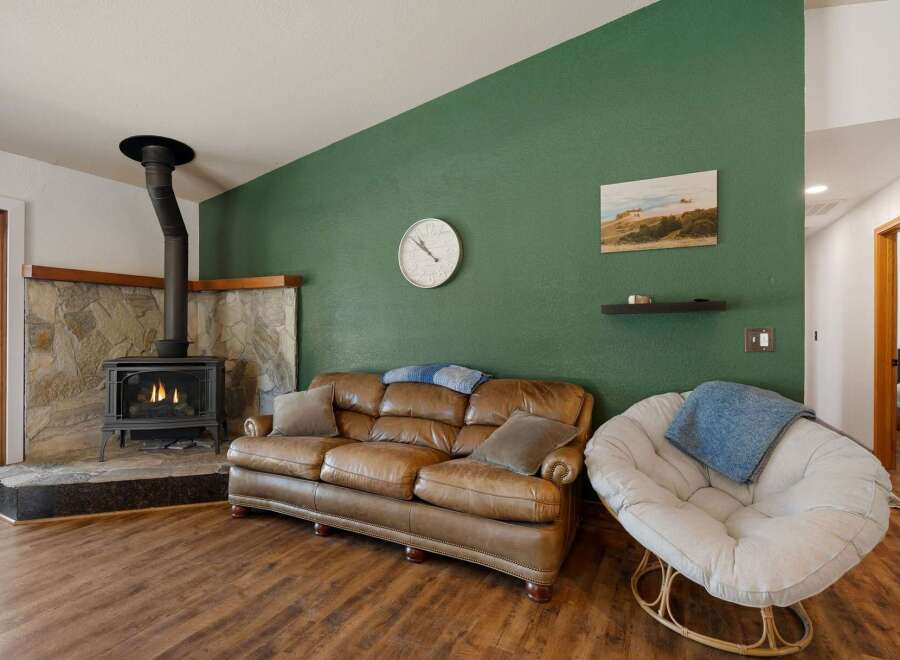 Cozy living room featuring a rustic stone fireplace with a wood-burning stove, perfect for chilly evenings.