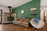 Cozy living room featuring a rustic stone fireplace with a wood-burning stove, perfect for chilly evenings.