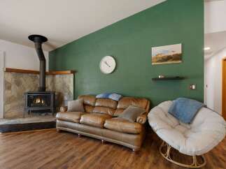Cozy living room featuring a rustic stone fireplace with a wood-burning stove, perfect for chilly evenings.