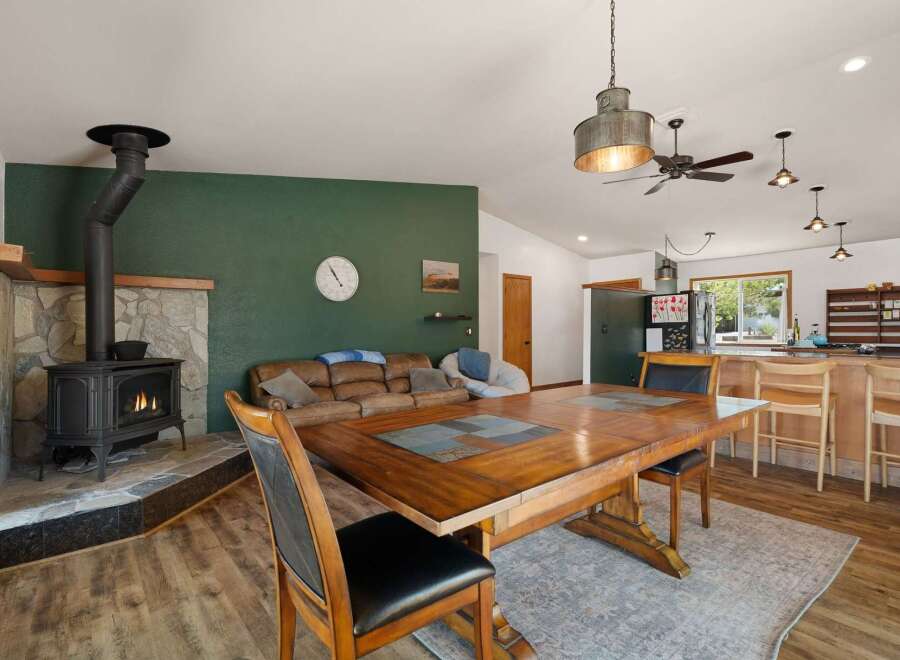 Cozy living space featuring a rustic stone fireplace with a wood-burning stove, perfect for gathering on cool evenings.