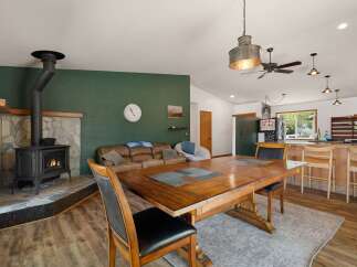 Cozy living space featuring a rustic stone fireplace with a wood-burning stove, perfect for gathering on cool evenings.