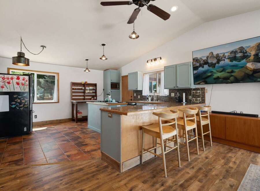 Discover this charming kitchen featuring light blue cabinetry and a spacious island with bar seating, perfect for casual dining.