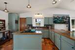 This spacious kitchen boasts light blue cabinetry and granite countertops, offering a modern and inviting atmosphere.