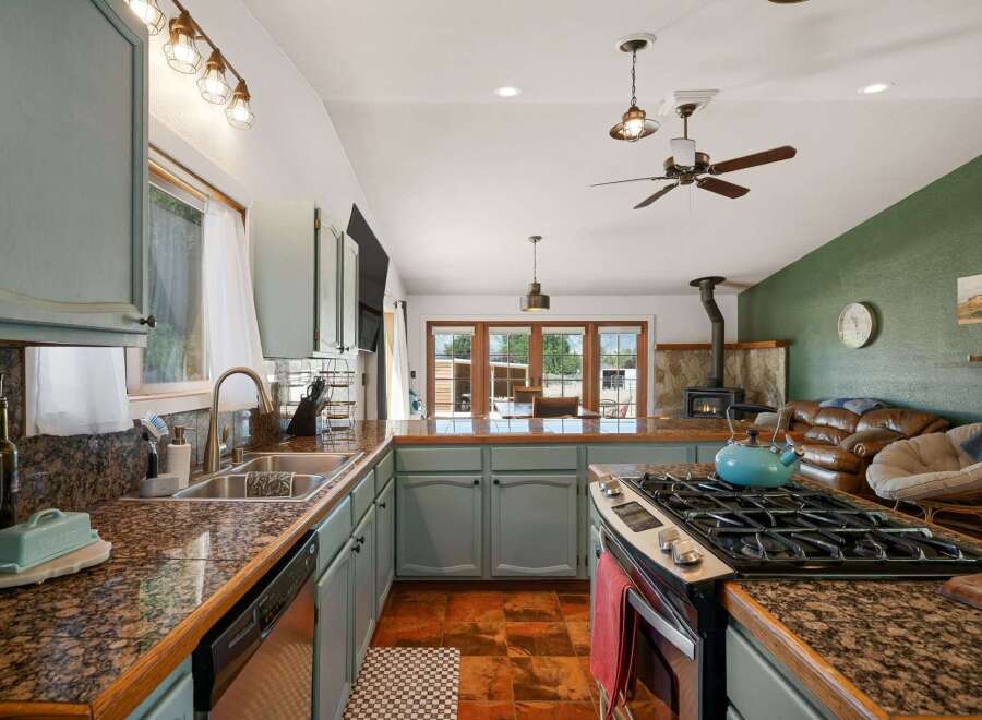 This spacious kitchen boasts granite countertops and light blue cabinetry, perfect for any home chef.
