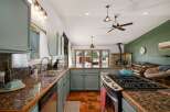 This spacious kitchen boasts granite countertops and light blue cabinetry, perfect for any home chef.