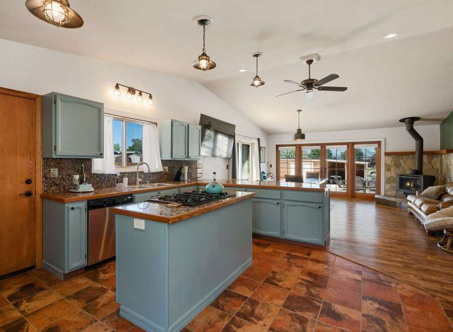 This spacious open-concept kitchen and living area features a large island with a gas stovetop, perfect for cooking and entertaining.