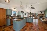 This spacious open-concept kitchen and living area features a large island with a gas stovetop, perfect for cooking and entertaining.