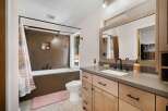 This modern bathroom features a sleek design with a deep soaking tub and a separate toilet area.