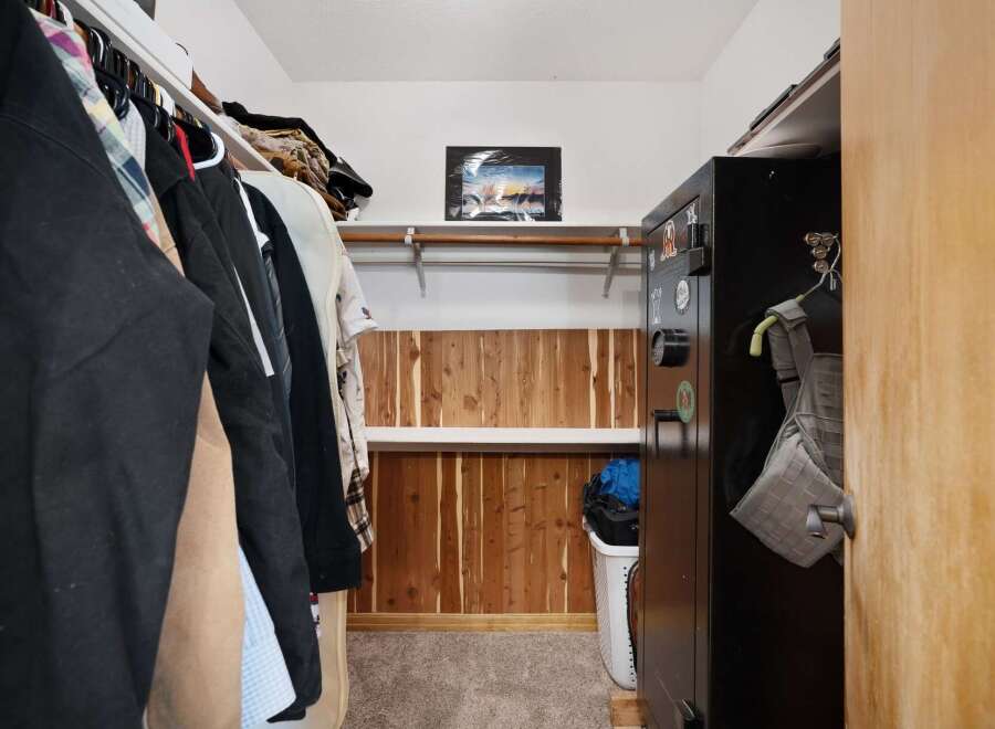 Discover ample storage in this walk-in closet, featuring a convenient hanging rod and shelving.