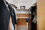 Discover ample storage in this walk-in closet, featuring a convenient hanging rod and shelving.