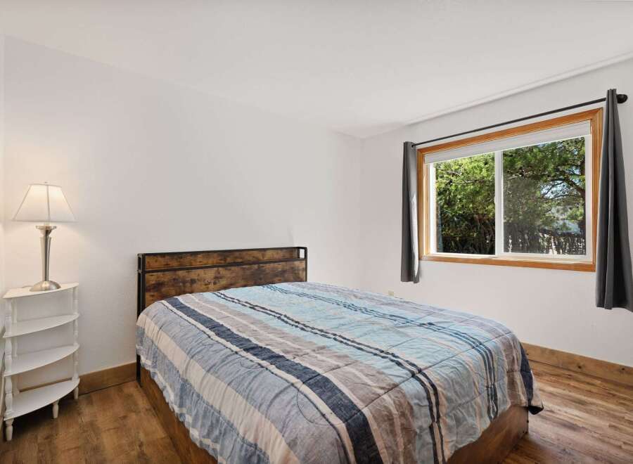 This charming bedroom features a comfortable bed with a striped comforter, perfect for a restful night's sleep.