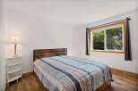 This charming bedroom features a comfortable bed with a striped comforter, perfect for a restful night's sleep.