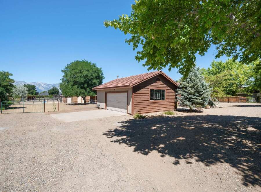 Discover this charming property featuring a detached garage with a classic tile roof and wood siding, perfect for vehicle storage or a workshop.