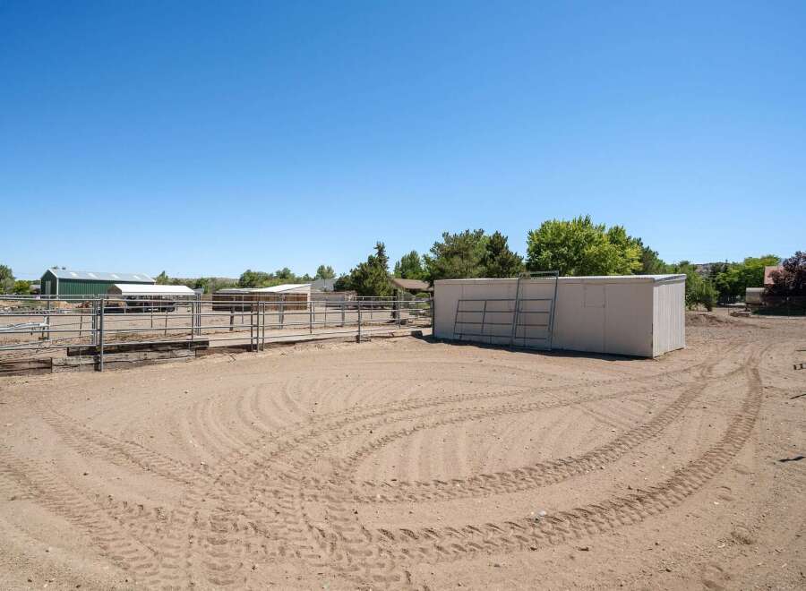 This property features a spacious outdoor arena with ample room for training and exercise, complete with sturdy metal fencing for safety.