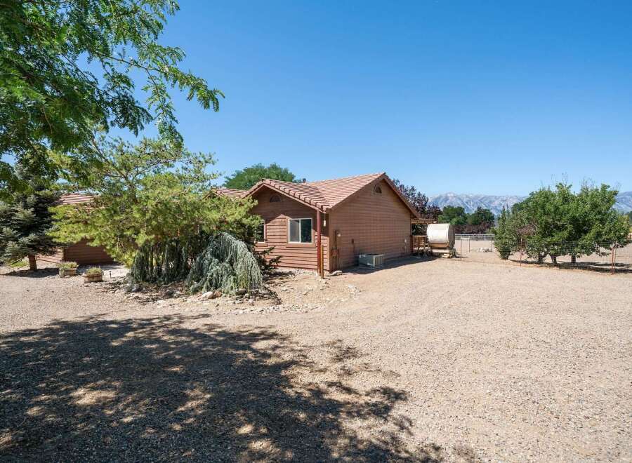 Discover this charming property featuring a cozy wooden home nestled amidst mature trees and a serene landscape.