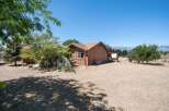 Discover this charming property featuring a cozy wooden home nestled amidst mature trees and a serene landscape.