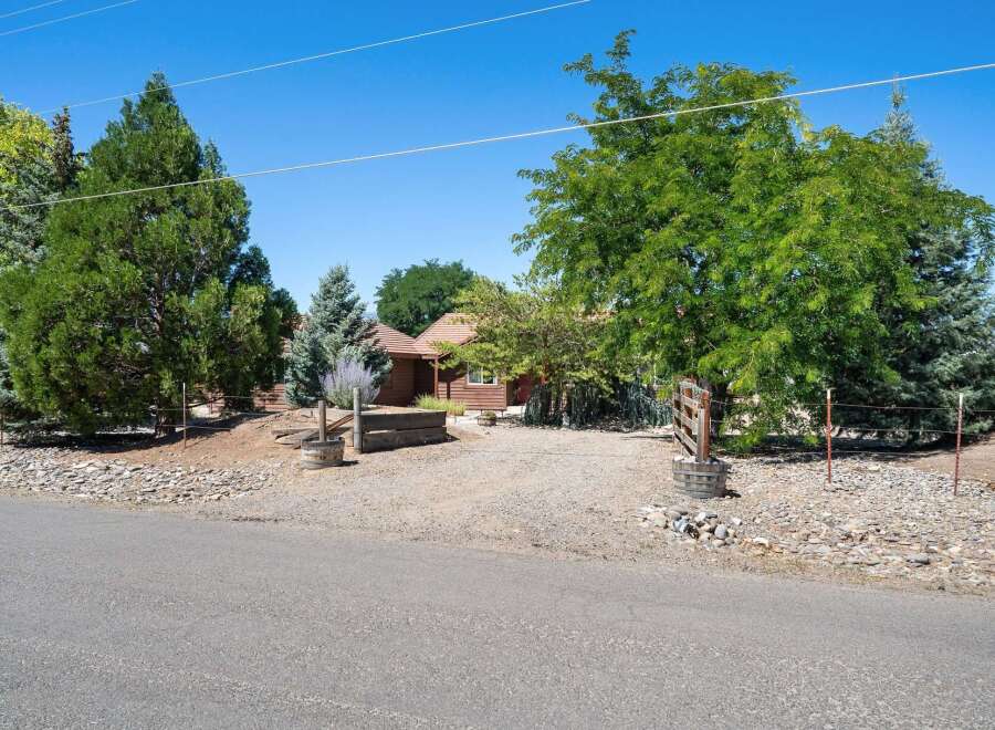 Nestled amidst mature trees, this charming property offers a serene retreat with a rustic aesthetic.