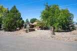 Nestled amidst mature trees, this charming property offers a serene retreat with a rustic aesthetic.