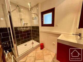 This modern bathroom features a spacious glass-enclosed shower with dual showerheads, perfect for a relaxing experience.