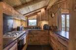 Experience rustic charm in this mountain kitchen, featuring warm wooden cabinetry and exposed beams that create a cozy, inviting atmosphere.