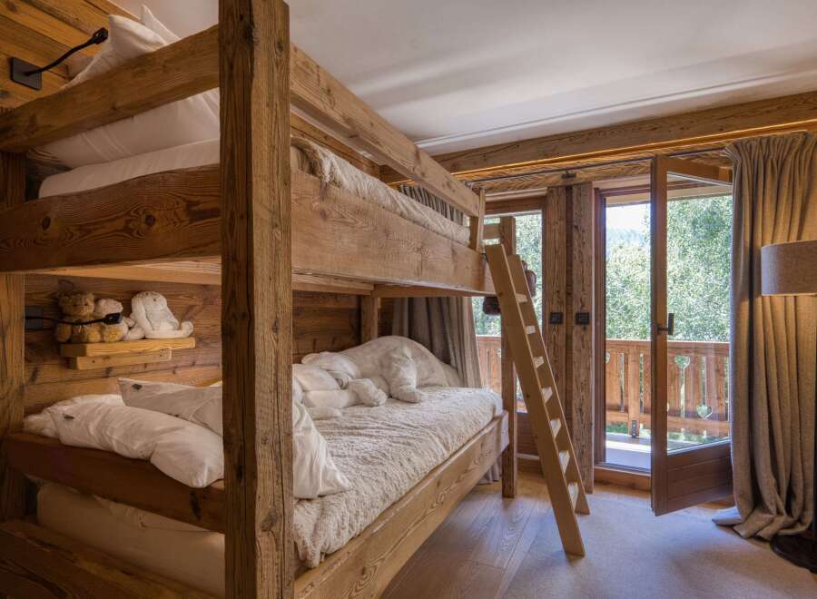Experience cozy mountain living in this charming bedroom featuring a rustic wooden bunk bed.