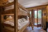 Experience cozy mountain living in this charming bedroom featuring a rustic wooden bunk bed.