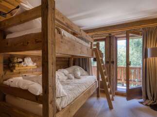 Experience cozy mountain living in this charming bedroom featuring a rustic wooden bunk bed.