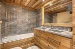 Experience rustic luxury in this stunning bathroom, featuring a deep soaking tub and a spacious double vanity with stone countertops.
