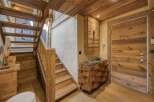 Experience rustic charm in this mountain chalet featuring a beautiful wooden staircase and a unique geometric cabinet.