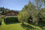 Nestled amidst lush greenery and mature trees, this charming wooden chalet offers a serene mountain retreat.