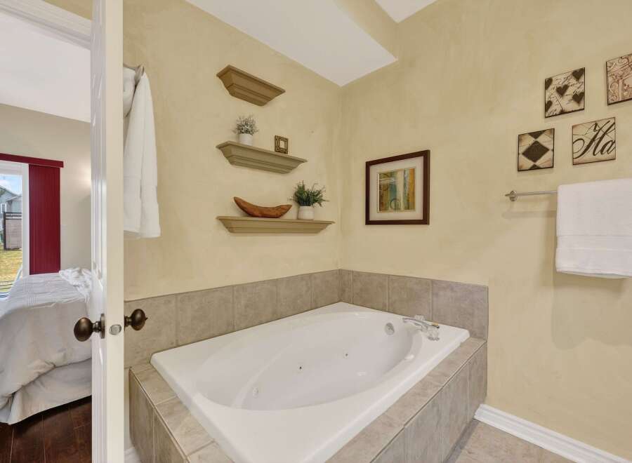 Indulge in relaxation in this luxurious bathroom featuring a spacious corner jacuzzi tub, perfect for unwinding after a long day.
