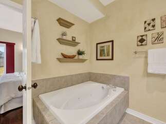 Indulge in relaxation in this luxurious bathroom featuring a spacious corner jacuzzi tub, perfect for unwinding after a long day.