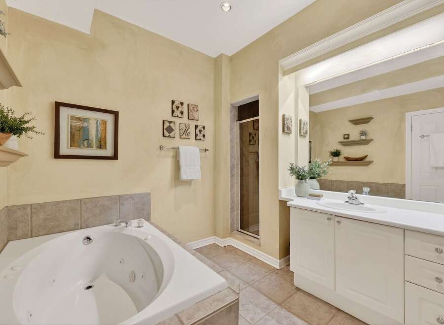 Indulge in relaxation in this luxurious bathroom featuring a spacious corner jacuzzi tub perfect for unwinding.